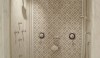 A bells and whistles shower with body sprays and hand shower, a ceiling mounted shower head and a wall mounted head.