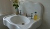 I love the exaggerated backsplash on this sink and its' very glamorous metal legs. The little stool fits perfectly under the sink.