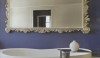 Luxeinteriorsanddesigns_Vol8Issue2_ The modern .25 freestanding tub is a wonderful juxtaposition against the large decorative mirror and brilliant blue wall. The proportion of the mirror gives the right scale to the design.