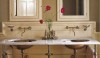When using a double washstand, the mass seems more managable with the use of two medicine cabinets and three sconces. It creates good balance to break up the space in this manner.