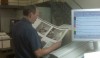 An experienced pressman checking the pages before sending through the press.