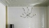 Tiled-dining-room-wall_Remodelista-e1299883307482 We don't usually see tile used in dining rooms. Here a simple white 2 x 6 tile with a matching white grout adds a reflective quality and texture to one wall in the space.