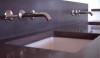 Clean concrete countertop and backsplash allows the wall mount faucets to stand out in this industrial modern design.