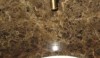 The antique brass finish on the faucet looks interesting against the Dark Emperador marble to create a beautiful tonal effect.