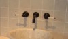 A vessel sink is a popular option with a wall mount faucet, although it can reduce useable counter space. A classic Carrara marble sink is shown here with an architectural bronze finish.