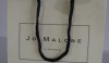 Lovely, ladylike Jo Malone has created a classic soft cream colored bag with black trim to hold her delightful fragrances.