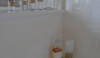 A view of the knee wall with some pharmaceutical bottles and a useful corner shelf that holds bath amenities.