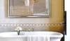 Very modern art above a traditional footed tub.  A great juxtaposition.