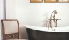 Art, a chair for conversation, a comfortable tub with an appropriate fitting and the warm texture of a floor make this a delightful space.