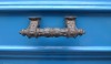 An elaborately detailed and decorative handle, left to tarnish, looks great against the bright blue door.