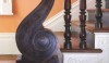 219 A bold period S-shaped mahogany newel post at the base of the main stair in a Charleston house restored by Gil Schafer Architects.