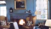 217 The formal library in a house in Maine painted in a bright, old fashioned 18th century turquoise. It has panels of red linen curtains set in arched reveals. Beautiful millwork, a Tabriz reproduction carpet and comfortable wing chairs frame the fireplace. Family furniture creates a space with historical connections.
