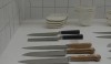 An artful arrangement of handsomely crafted chef's knives with different types of wood handles.