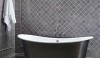 oval-bath-tubs-111935 A full wall of tile in a slightly lavender toned gray. The 3x3 tiles set on the diagonal are framed by 6x6 tiles and a molding. A well shaped baseboard finishes the installation.