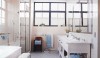 The simple form of a wood washstand with its open storage makes a modern statement. The scale of this space is long and narrow, yet all of the elements seem to have enough space.