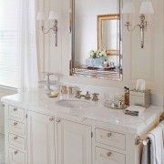 A simple vanity with bracket feet is beautifully accessorized with personal objects neatly collected on a tray.