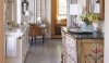 A dramatic serpentine front hand painted piece of furniture takes this all white bathroom to one that is truly exceptional.