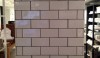 58th Street A good example of 'old New York' subway tile with a charcoal grout. Instead of making the columns disappear, the gray grout draws you to them.