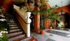 Addison Mizner_The Everglades Club_Palm Beach Post3 An interior view of the Everglades Club with typical Mizner colorful tile decoration on the stair risers, an exposed wood ceiling and colorful interior wall color.