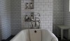 Remodelista_A gymnasium-style bath in the UK A standard 'subway' 3 x 6 tile installed with light gray grout feels like a gym. I love the 2 niches for corralling bathing amenities.